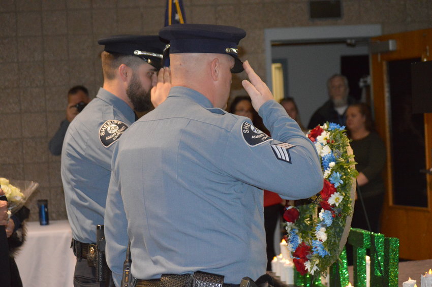 Members of the Adams County Sheriff's Department honor guard salute a wreath honoring slain deputy Heath Gumm at a vigil in his honor Jan. 24 -- the one year anniversary of his death.